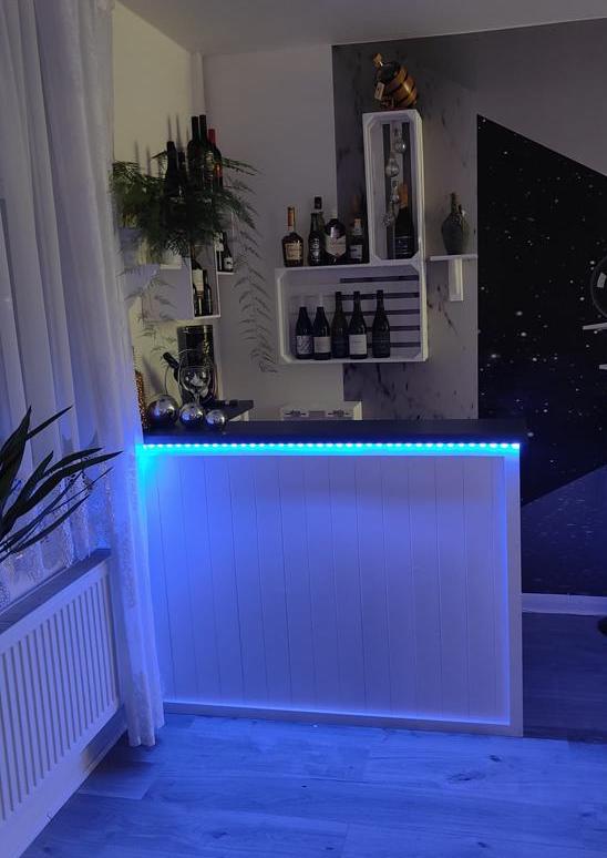 Evening entertaining corner with glowing LED lights on Lumi Slate White Martini 140x80 L-shape home bar